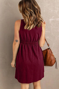 a woman in a maroon dress holding a brown purse