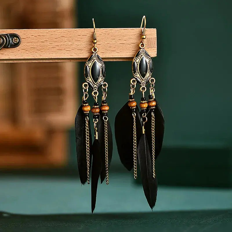 a pair of black feathers hanging from a hook
