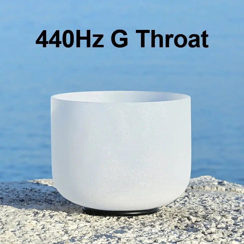 a white singing bowl sitting on a stone 440 Hz G Throat