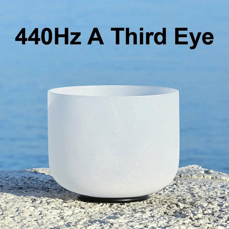 a white singing bowl sitting on a stone 440Hz A Third Eye