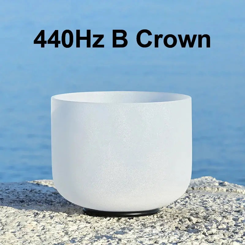 a white singing bowl sitting on a stone 440Hz B Crown