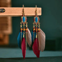 a pair of colorful feathers hanging from a hook