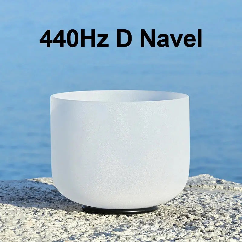 a white singing bowl sitting on a stone 440Hz D Navel