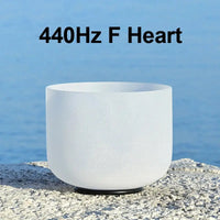 a white singing bowl sitting on a stone 440Hz F Heart