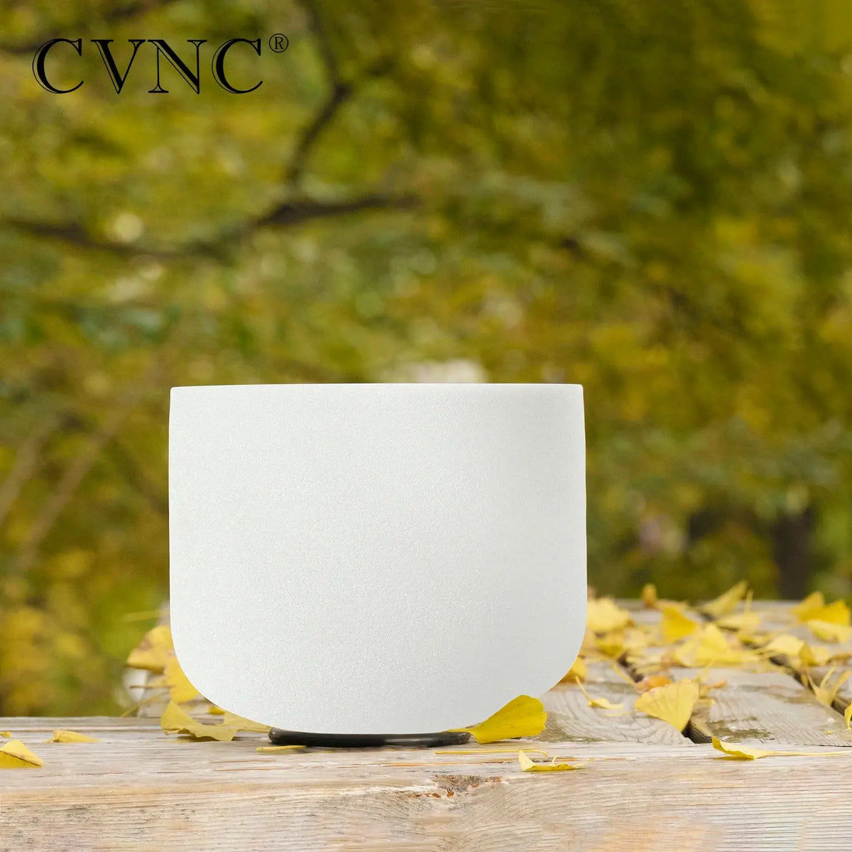 a white singing bowl sitting on top of a wooden table