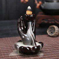 a figurine of a hand holding a candle on a table