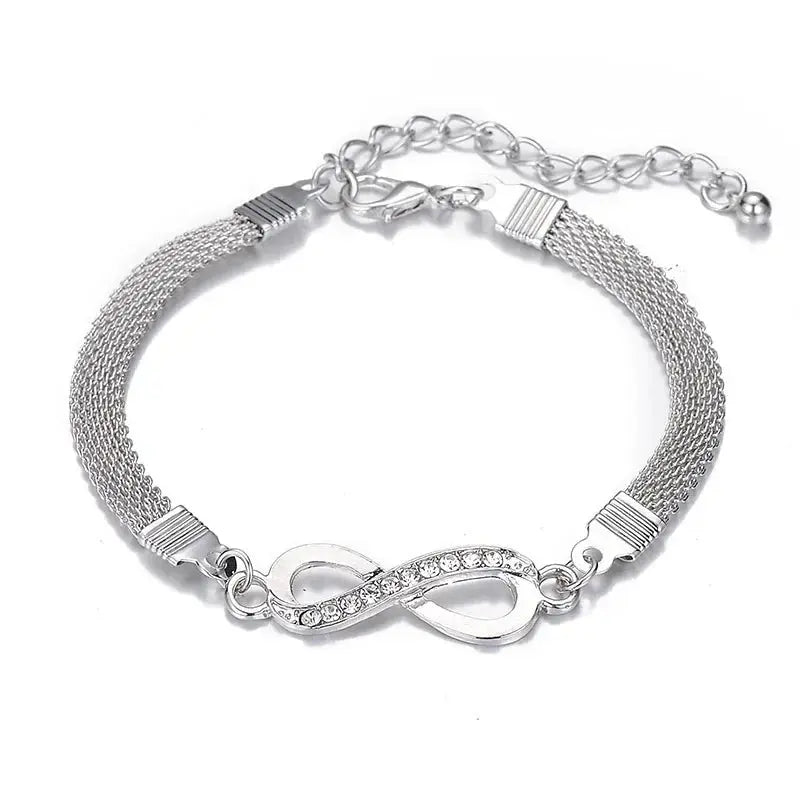 a silver bracelet with rhinestone accent on a white background