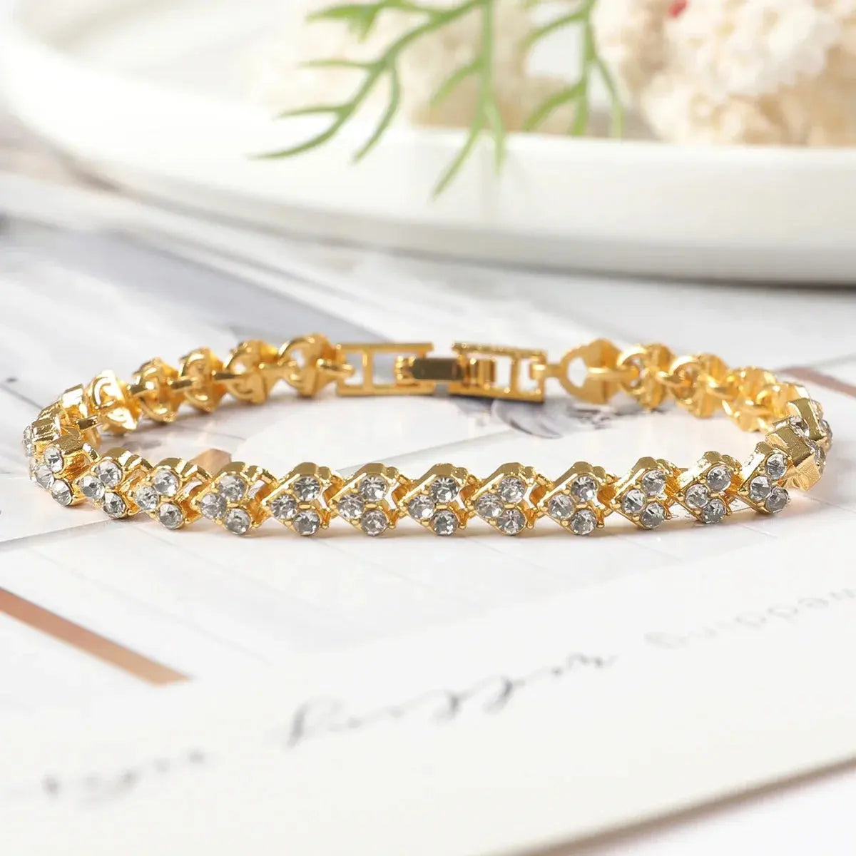 gold bracelet with rhinestones placed in heart shape 