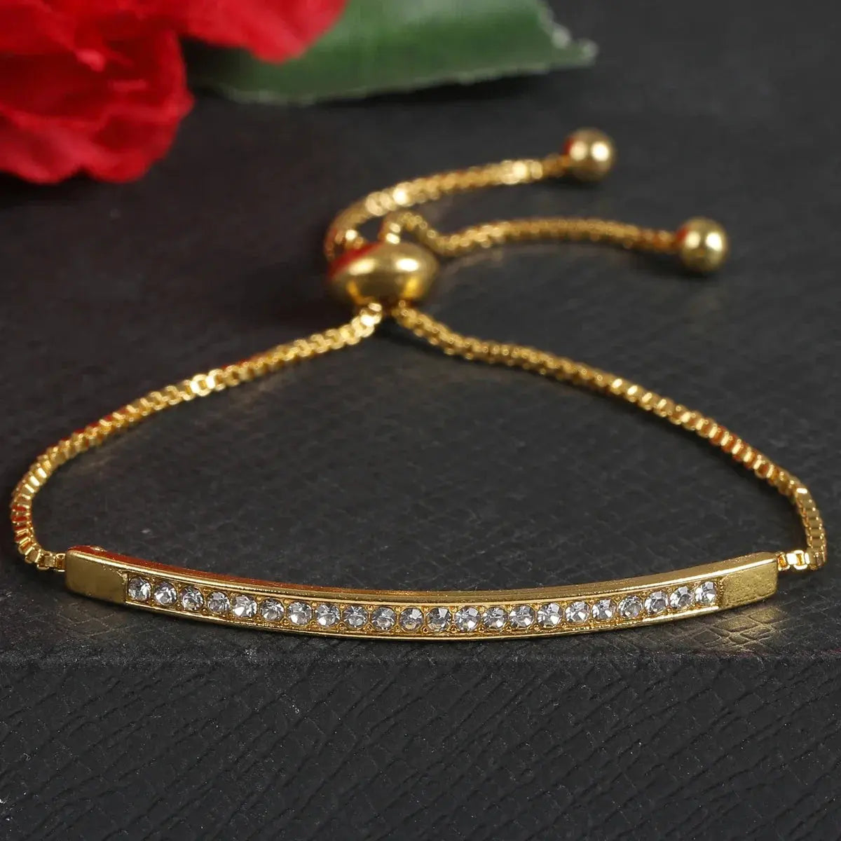 gold bracelet with rhinestones on a gray background