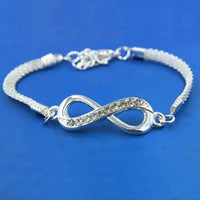 a silver bracelet with a diamond accent on a blue background