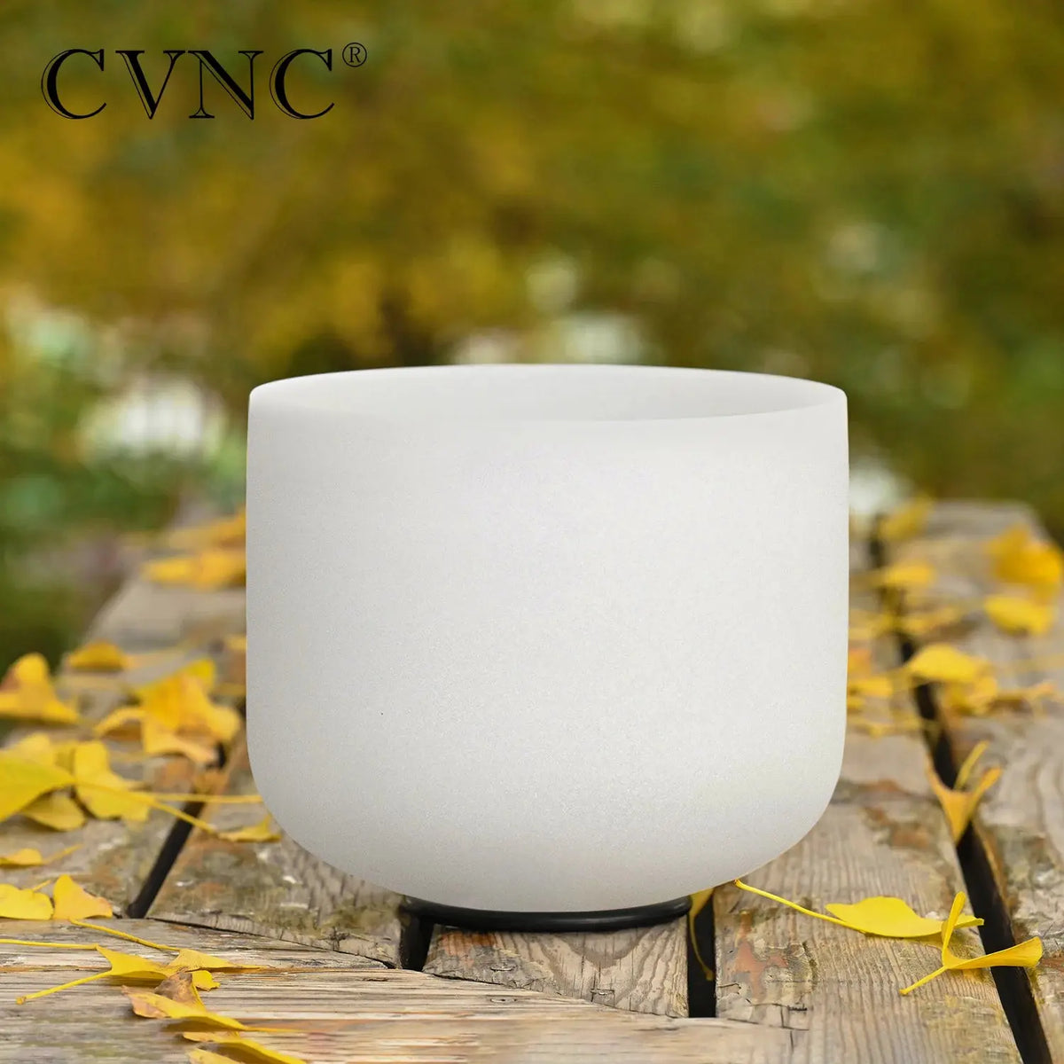 a white singing bowl sitting on top of a wooden table