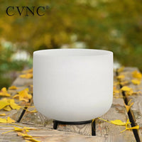 a white singing bowl sitting on top of a wooden table