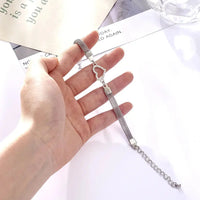 woman holding a silver bracelet with a heart charm on it