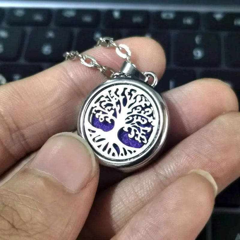 a person is holding a tree of life necklace