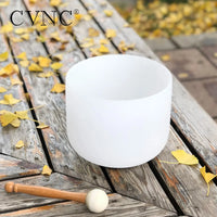 a white singing bowl sitting on top of a wooden table