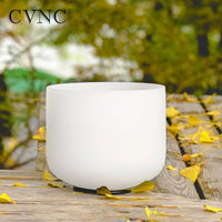 a white singing bowl sitting on top of a wooden table