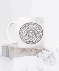 a white coffee mug with a design on it