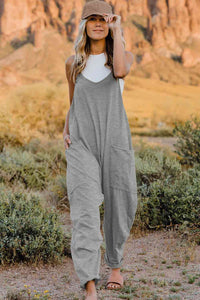 a woman wearing a grey jumpsuit and a hat