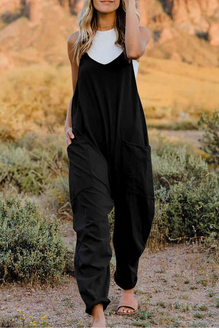a woman wearing a black jumpsuit and a white top