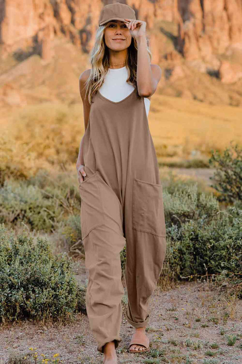 a woman wearing a tan jumpsuit and a hat